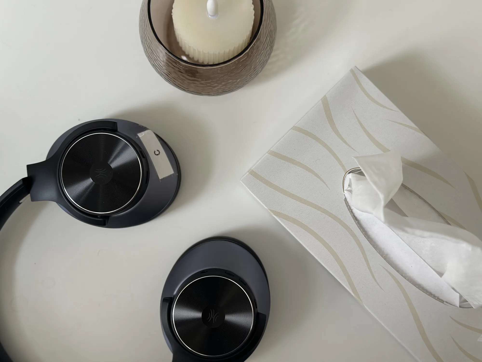 Noise-cancelling headphones, a candle, and tissues laid out for patient comfort
