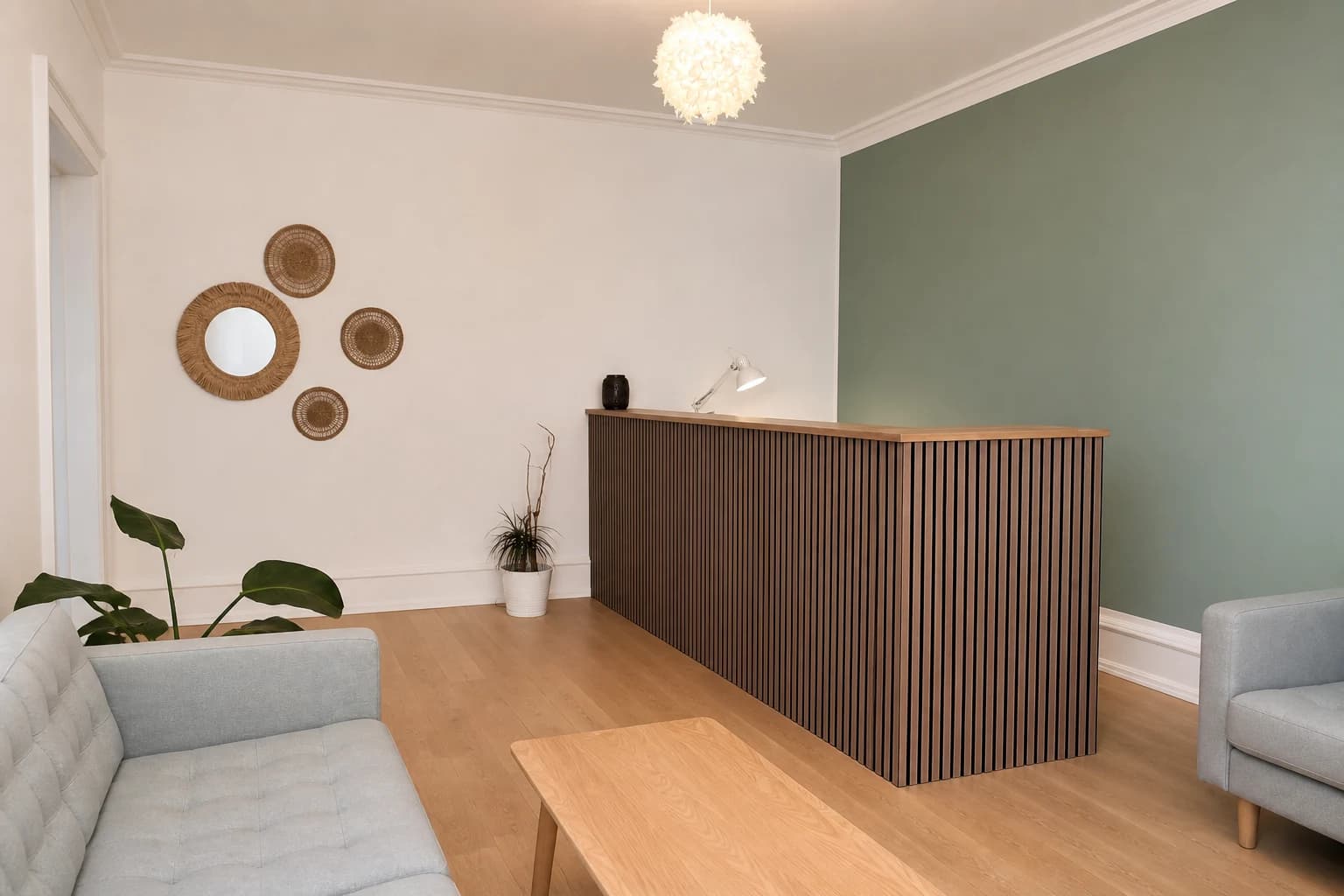 Premier Fertility Clinic's reception with an oak-slat desk, sage walls, woven wall decor, and grey seating
